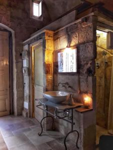 马泰拉Cave Rooms Sassi的石墙内带水槽的浴室