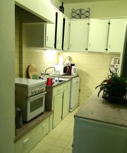 里斯本A casa do bairro的厨房配有白色橱柜和炉灶。