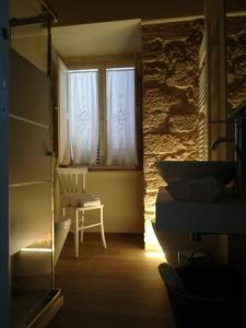 拉波拉诺泰尔梅Appartamento il castellare的一间卧室配有一张床和一个带椅子的窗户