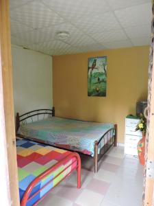 Pajonal ArribaHostal Familiar El Ángel Panamá B&B的卧室配有一张床,墙上挂有绘画作品