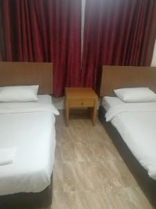 安曼埃尔祖莉耶酒店的红色窗帘间内的两张床
