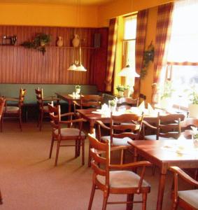 石勒苏益格多姆霍特尔住宿加早餐旅馆的用餐室配有木桌和椅子