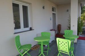 圣尼科拉阿尔切拉Quiero Más B&B的一个带绿色桌椅的庭院和窗户