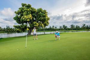 蓬塔卡纳全包巴塞罗巴瓦罗海滩客房 - 仅限成人入住的两人在高尔夫球场打高尔夫
