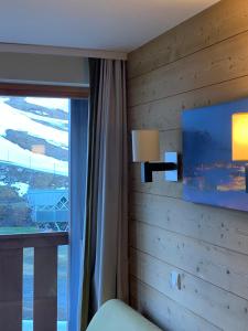 葱仁谷Val Thorens Temple of the Sun - ski in, ski out的一间卧室设有木墙和窗户
