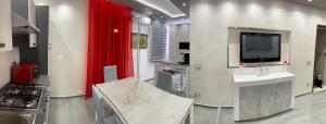 夏卡Deluxe Home appartamento的厨房设有电视和红色窗帘