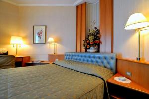SorisoHotel Ristorante Al Sorriso的一间位于酒店客房的卧室,配有蓝色的床