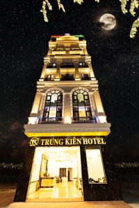 海防TRUNG KIÊN HOTEL的一座高大的建筑,晚上有标志