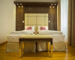 维也纳阿卡迪亚贝斯特韦斯特酒店的卧室配有一张带白色床单和粉红色枕头的大床。