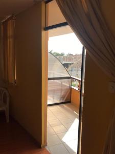 万查科Hotel Sol de Huanchaco的一间设有玻璃门和阳台的客房