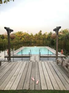 珍南海滩Kunang Kunang Heritage Villas的一个带木甲板和木板路的游泳池