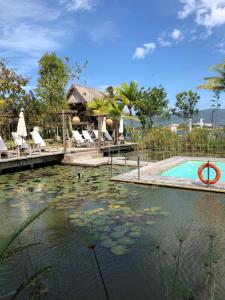 珍南海滩Kunang Kunang Heritage Villas的度假村旁边的水中设有百合垫的游泳池