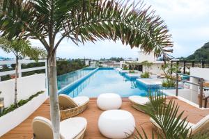 长滩岛费拉酒店和花园套房的一座带椅子和棕榈树的建筑屋顶上的游泳池