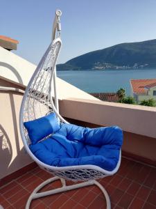 赫尔采格诺维Villa Nena的阳台配有带蓝色枕头的秋千椅