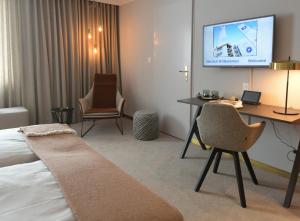达沃斯孔格里斯酒店的酒店客房设有一张床、一张书桌和一台电视机。