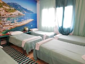 兰卡Can Pau Guesthouse的带三张床的客房和海滩画
