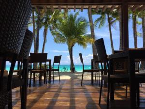 长滩岛357长滩岛度假村 的海滩上的餐厅,种有棕榈树,享有海景