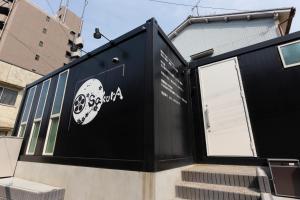 名古屋SakurA的一座黑色的建筑,旁边有一个标志