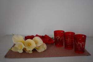 科尔丘拉Fantasy Apartment的桌子上放着一组红杯和鲜花