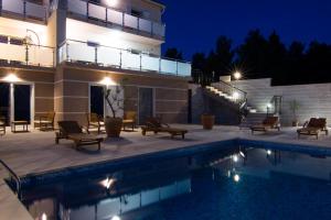 波尔Villa Nikola - pool side apartments的夜间带游泳池的别墅