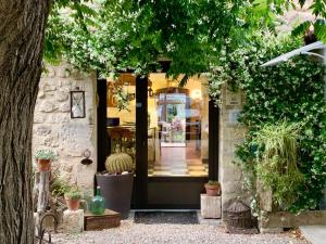 丰维耶Logis Hotel Restaurant Hostellerie de la Tour的一间藏有盆栽植物的商店的前门