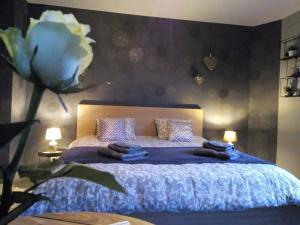 艾瓦耶Votre Horizon的卧室配有一张蓝色的床,墙上挂着鲜花