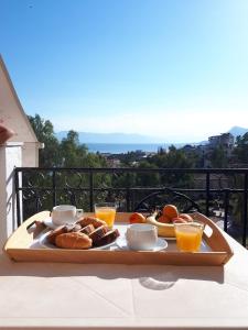 艾迪普索斯Ξενοδοχείο 'ΠΑΛΛΑΔΙΟΝ' Hotel 'PALLADION'的桌上的食品托盘,配以橙汁