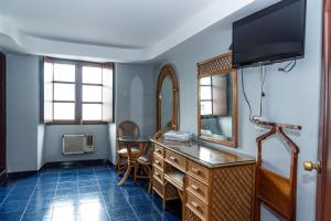 韦拉克鲁斯Hotel Santander Veracruz - Malecon的客房设有带镜子的书桌和电视。