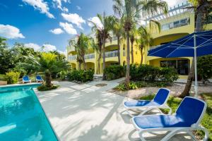 格雷斯湾格雷斯湾公寓式酒店的一个带游泳池和椅子的度假胜地和一座建筑