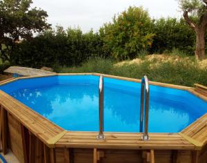 Trecastelli"La Casa degli ulivi Art B&B"的一个带木甲板的游泳池和一个蓝色的游泳池