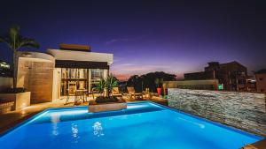 圣玛尔塔Alko Hotel Cotona的夜间在房子前面的游泳池