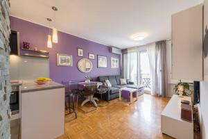 斯普利特Apartman "Bubi"的厨房以及带紫色墙壁的客厅。