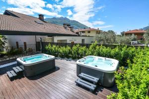 托尔博莱Villa degli Olivi Relais的木甲板上的一个热水浴缸