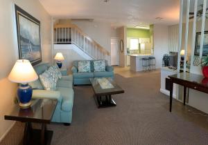 加尔维斯敦海湾四季别墅的客厅配有蓝色的沙发和桌子