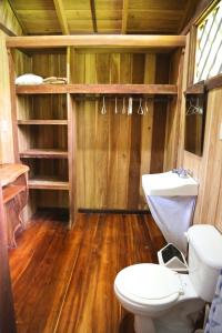 卡维塔Hotel & Cabinas Nadine的一间带卫生间的浴室,铺有木地板。
