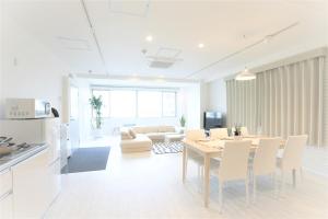 大阪BIG ROOM GUEST HOUSE的用餐室以及带桌椅的起居室。