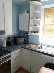 伦敦Dream Time Apartments-Aqua Suite的厨房配有白色橱柜和水槽