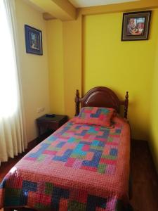塔克纳El Marquez的一间卧室,床上有五颜六色的被子