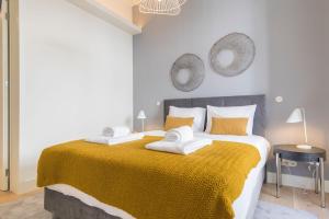 里斯本Ando Living - Santa Justa 79 Townhouse的一间卧室配有一张带黄色毯子的大床