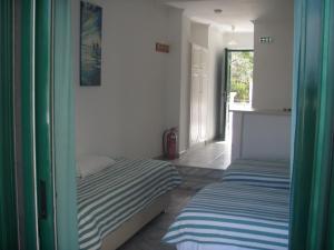 卡沃斯UMBRELLA BEACH APARTMENTs的一间卧室设有两张床,一扇门设有窗户