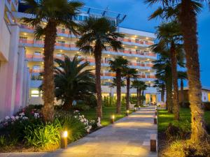 比比翁Bibione Palace Spa Hotel的一座楼前有棕榈树的酒店