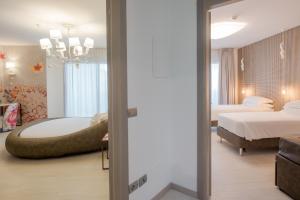 比比翁Bibione Palace Spa Hotel的卧室配有床和浴缸