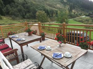 上柯尼希山麓米尔巴赫瑞丁民宿的阳台上配有两张木桌和椅子,享有美景。