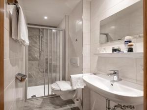 巴特霍夫加施泰因阿尔本霍夫酒店的浴室配有卫生间、盥洗盆和淋浴。