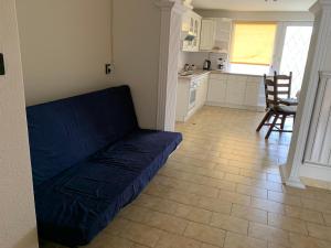 布达佩斯Family room for 4-6 person的一间带蓝色沙发的客厅和一间厨房