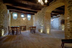 圣莱奥Palazzo Serre - Natura & Piscina的石头建筑中带桌椅的用餐室