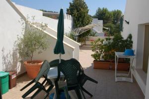 圣凯撒利亚温泉Case Vacanza La Serricella的庭院配有两把椅子、一张桌子和一把遮阳伞