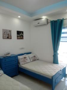 帕拉利亚卡泰里尼斯B&A Paralia的一间卧室设有蓝色的床和窗户。