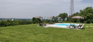 帕斯特伦戈Poggio di Pastrengo的草地上的游泳池,配有两张桌子和椅子