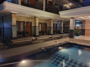 库塔瓦纳库布寄宿家庭旅馆的一座带椅子的建筑中的游泳池